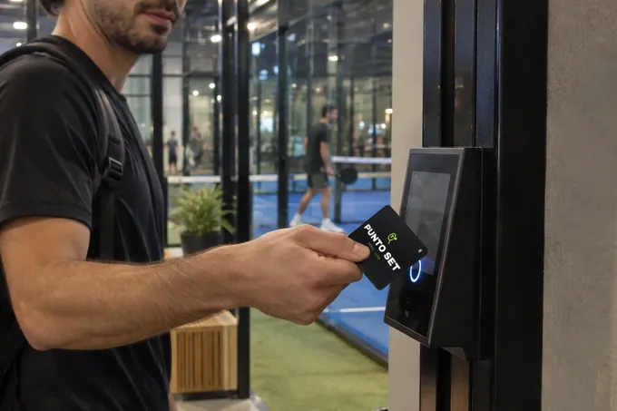 En la entrada de un club de pádel, un jugador acerca su NOIR card de Punto Set al lector